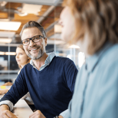 Smiling businessman in discussions with female colleague